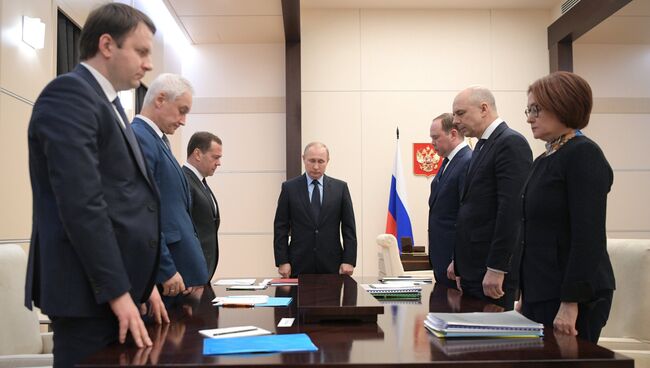 Президент РФ Владимир Путин и участники совещания по экономическим вопросам во время минуты молчания в знак траура по погибшим при пожаре в Кемерове. 28 марта 2018