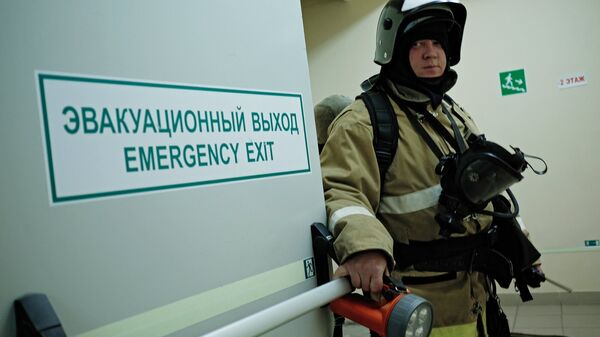 Сотрудник противопожарной службы у эвакуационного выхода во время учений в торговом центре Галерея Краснодар