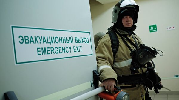 Сотрудник противопожарной службы у эвакуационного выхода во время учений в торговом центре Галерея Краснодар