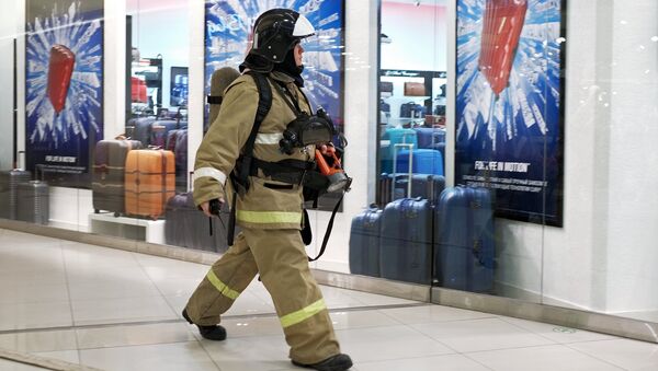 Сотрудник противопожарной службы у эвакуационного выхода во время учений в торговом центре