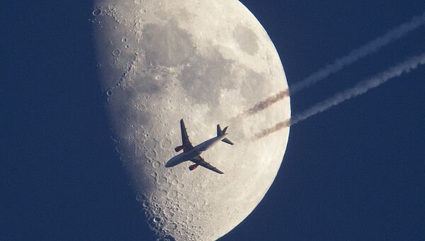 Самолет пролетает на фоне луны. Архивное фото
