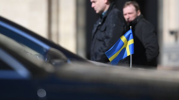 Автомобиль с флагом Швеции и прохожие