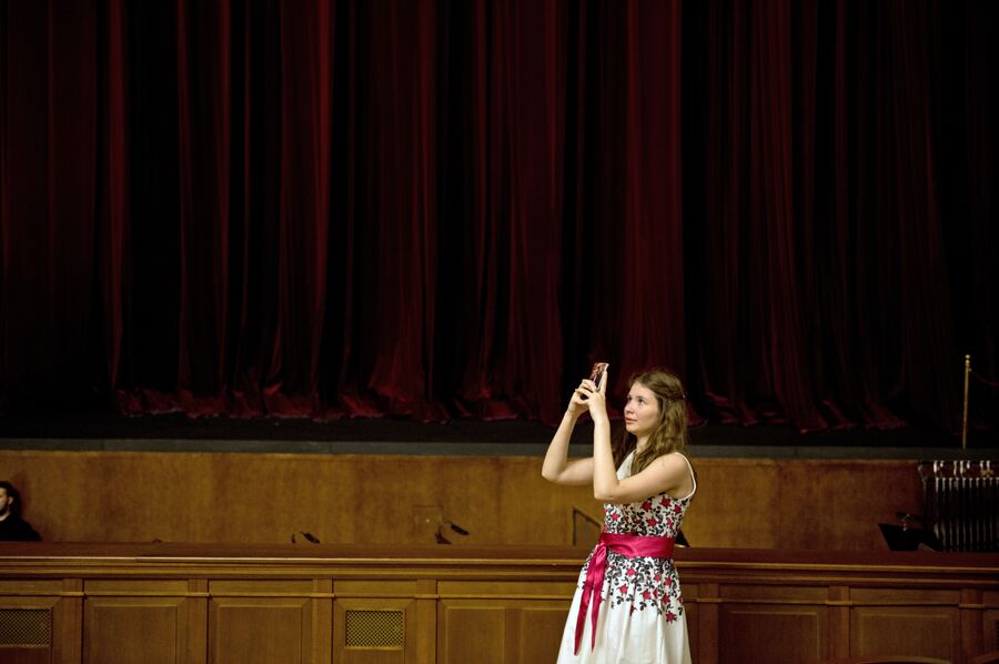 Зрительница делает фотографию в зрительном зале Новосибирского оперного театра перед началом спектакля