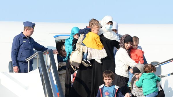 Дети и родители, возвращенные из Сирии, выходят из самолета в аэропорту Грозного
