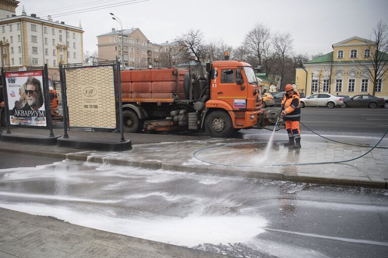 Сотрудник коммунальных служб моет тротуар шампунем в Москве Сотрудник коммунальных служб моет тротуар шампунем в Москве