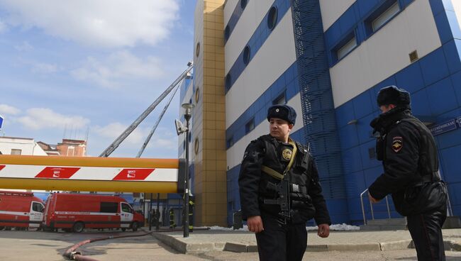 Сотрудники правоохранительных органов у детского торгового центра Персей в Москве, где произошло возгорание. 4 апреля 2018