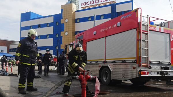 Сотрудники противопожарной службы МЧС РФ у детского торгового центра Персей в Москве, где произошло возгорание