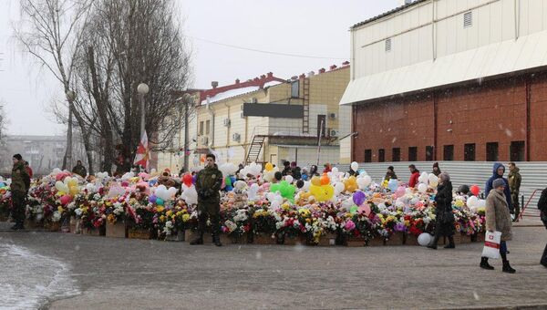 Охранники возле стихийного мемориала из цветов и игрушек в Кемерово. Архивное фото