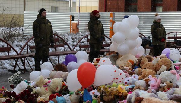 Охранники возле стихийного мемориала из цветов и игрушек в Кемерово. 5 апреля 2018