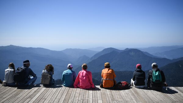 Туристы на обзорной площадке на вершине Роза Пик на высоте 2320 метров на горном курорте Роза хутор в Красной поляне.