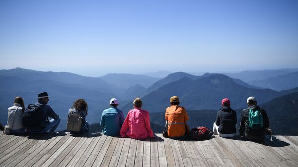 Туристы на обзорной площадке на вершине Роза Пик на высоте 2320 метров на горном курорте Роза хутор в Красной поляне.