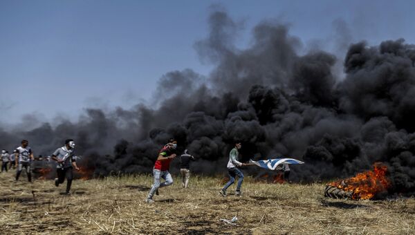 Палестинские протестующие во время столкновений с израильскими военными на границе сектора Газа и Израиля. Архивное фото