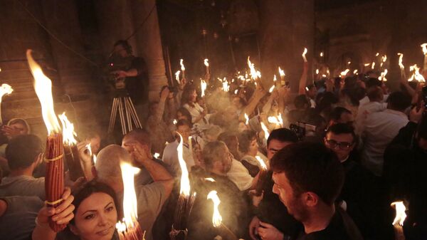 Верующие со свечами, зажженными от Благодатного огня в храме Гроба Господня. 7 апреля 2018