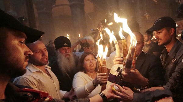 Верующие со свечами, зажженными от Благодатного огня. Архивное фото