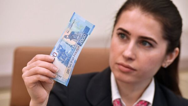 Девушка с купюрой 2000 рублей. Архивное фото