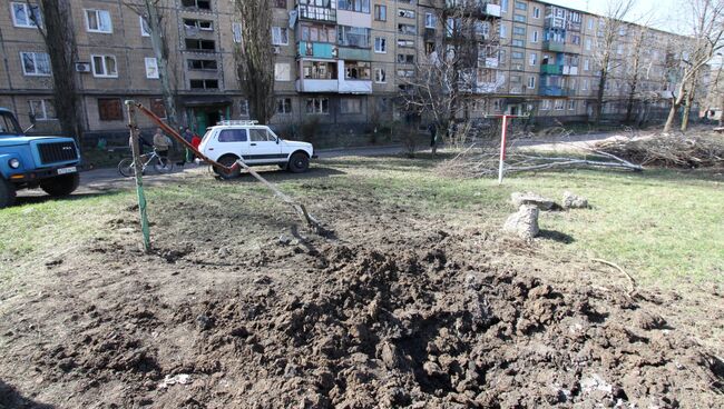 Воронка от снаряда во дворе жилого дома после ночного обстрела в Донецке. Архивное фото