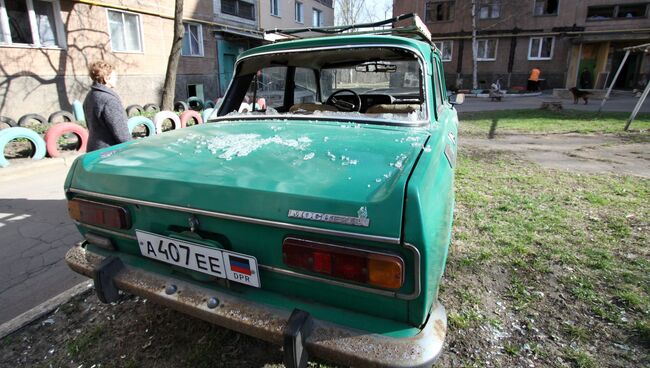 Поврежденный автомобиль во дворе жилого дома в Донецке. Архивное фото