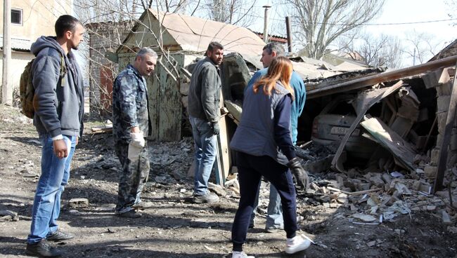 Местные жители Куйбышевского района у гаража, поврежденного в ходе ночного обстрела Донецка. Апрель 2018