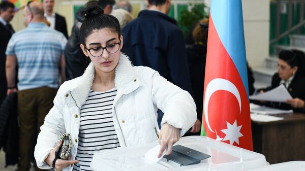 Девушка голосует на выборах президента Азербайджана на избирательном участке в Баку