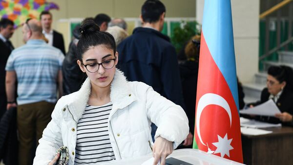 Девушка голосует на выборах президента Азербайджана на избирательном участке в Баку