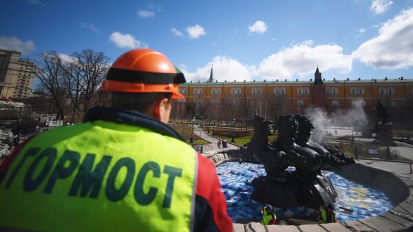 Сотрудник Гормоста во время промывки фонтана Времена года на Манежной площади в Москве