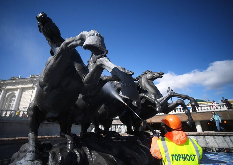 Сотрудник Гормоста производит промывку фонтана Времена года на Манежной площади в Москве