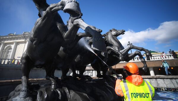 Сотрудник Гормоста производит промывку фонтана Времена года на Манежной площади в Москве