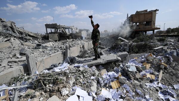 Сирийский солдат на месте разрушенного научно-исследовательского центра в Барзе, Сирия. 14 апреля 2018