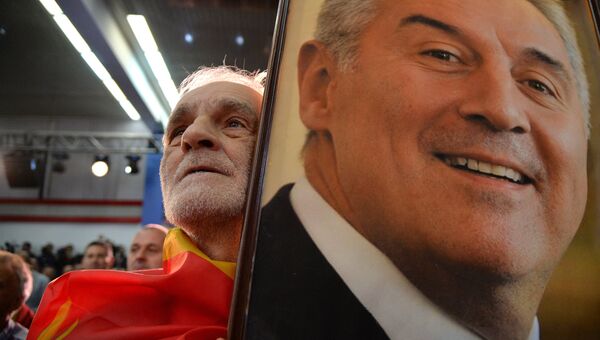 Мужчина с портретом лидера Демократической партии социалистов Черногории Мило Джукановича во время президентских выборов. 15 апреля 2018