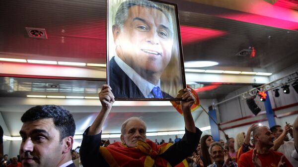 Мужчина с портретом лидера Демократической партии социалистов Черногории Мило Джукановича во время президентских выборов