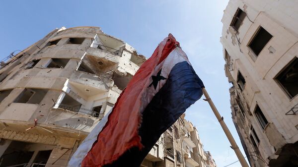 Сирийский флаг на разрушенной улице в Восточной Гуте. Архивное фото