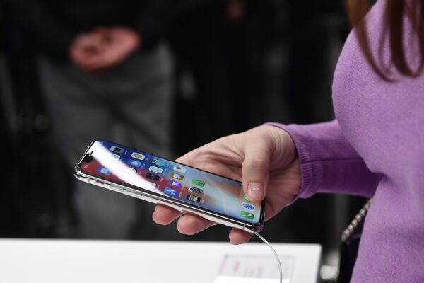 Покупательница рассматривает новый смартфон iPhone X Покупательница рассматривает новый смартфон iPhone X