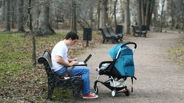 Молодой человек с коляской в Нескучном саду в Москве 