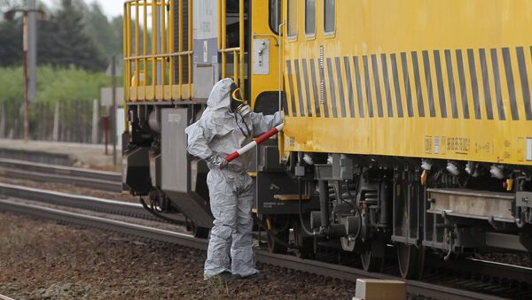 Мужчина в защитном костюме рядом с поездом, перевозящем химические вещества в Бельгии. Архивное фото