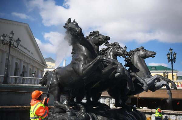 Сотрудник Гормост производит промывку фонтана Времена года на Манежной площади в Москве