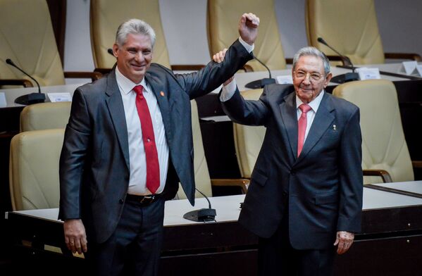 Рауль Кастро поднимает руку новому президенту Кубы Мигелю Диас-Канелю после того, как он был официально назначен Национальным собранием в Гаване. 19 апреля 2018 года