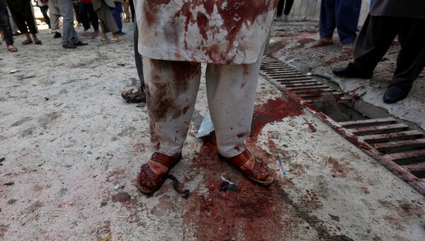 Человек, запятнанный кровью, на месте теракта, совершенного самоубийцей, в Кабуле, Афганистан. 22 апреля 2018