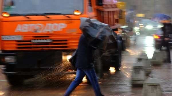Пешеходы на улице в Москве во время сильного ветра и дождя