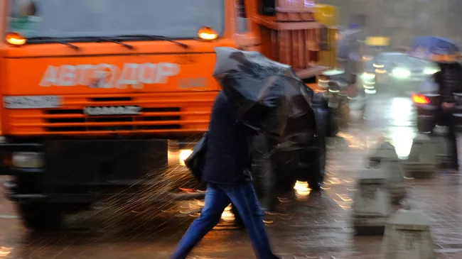 Пешеходы на улице в Москве во время сильного дождя