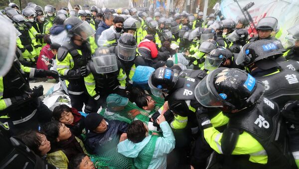 Полицейские разгоняют участников акции протеста против THAAD в Сонджу, Южная Корея. 23 апреля 2018