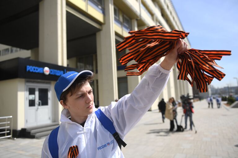 Волонтер раздаёт георгиевские ленточки на Зубовском бульваре в Москве в рамках ежегодной акции Георгиевская ленточка, посвященной 73-й годовщине Победы в Великой Отечественной войне