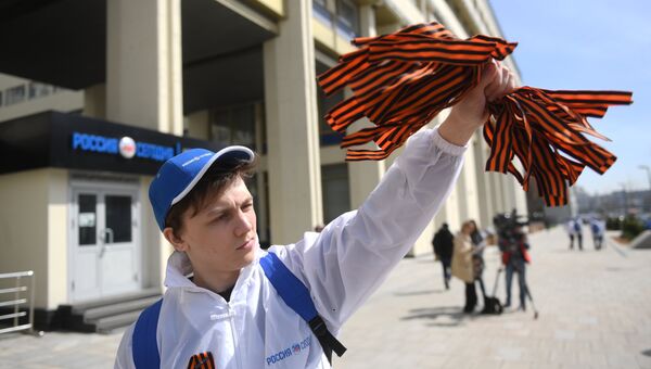 Волонтер раздаёт георгиевские ленточки на Зубовском бульваре в Москве в рамках ежегодной акции Георгиевская ленточка, посвященной 73-й годовщине Победы в Великой Отечественной войне