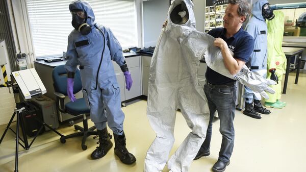 Сотрудник ОЗХО демонстрирует защитный костюм, использовавшийся экспертами во время расследования отравления Сергея Скрипаля в Великобритании