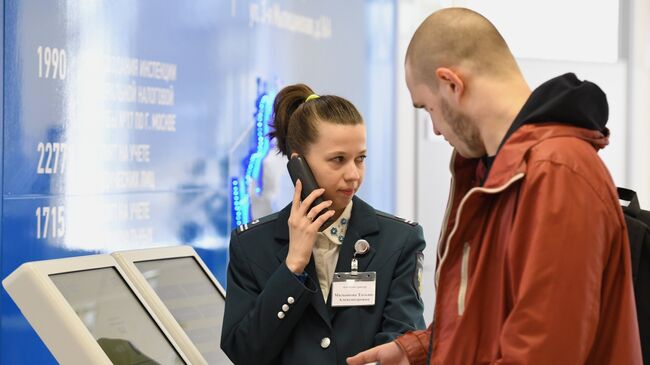 Сотрудница помогает посетителю со сдачей налоговой отчетности