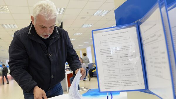 Посетитель заполняет документы в операционном зале инспекции Федеральной налоговой службы РФ в Москве. Архивное фото