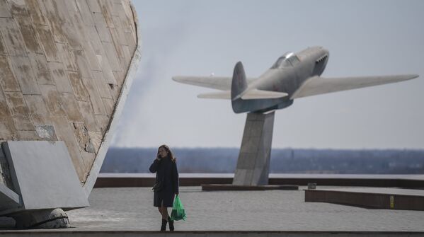 Девушка на территории музея-заповедника Сталинградская битва в Волгограде. На заднем плане - памятник самолету Як-3