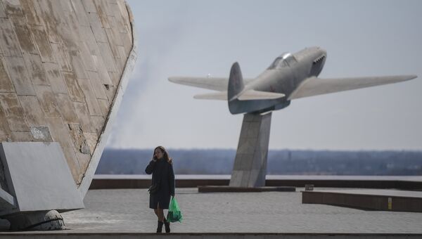 Девушка на территории музея-заповедника Сталинградская битва в Волгограде. На заднем плане - памятник самолету Як-3