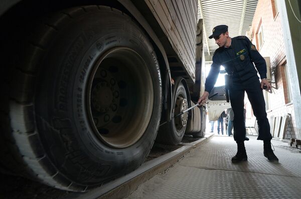 Сотрудник пограничной службы во время осмотра большегрузного автомобиля на многостороннем автомобильном пункте пропуска Пограничный в Приморском крае на российско-китайской границе Сотрудник пограничной службы во время осмотра большегрузного автомобиля на многостороннем автомобильном пункте пропуска Пограничный в Приморском крае на российско-китайской границе