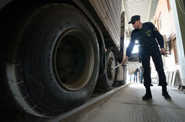 Сотрудник  пограничной службы во время осмотра большегрузного автомобиля на многостороннем автомобильном пункте пропуска Пограничный в Приморском крае на российско-китайской границе