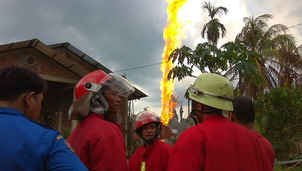 Пожарники на месте загорания нефтяной скважины в провинции Ачех, Индонезия. 25 апреля 2018